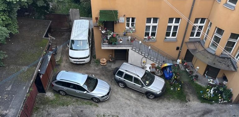 Na zdjęciu widok z góry na budynek i samochody przy ulicy Rybołowców 8 w Gdańsku