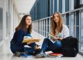 Female students sitting on the floor and reading notes before exam