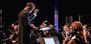 Na zdjęciu Adam Sztaba dyryguje orkiestrą podczas występu w w Suwałkach w ramach festiwalu "Wajda na Nowo"