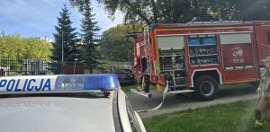 Pożar wybuchł w jednym z pokoi Na zdjęciu radiowóz oraz wóz strażacki na miejscu zdarzenia