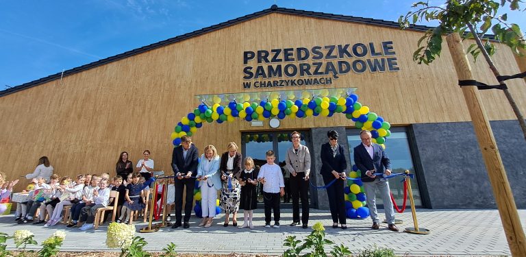 Na zdjęciu przedszkole samorządowe, przed którym stoją urzędnicy i dzieci. Uwieczniono moment przecięcia wstęgi