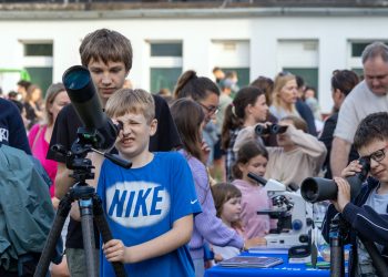 Na zdjęciu grupka dzieci która znajduje się pod Sopockim obserwatorium astronomicznym. Każdy z osobna ma swój teleskop i patrzą w niebo