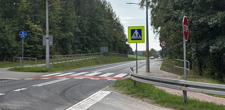 Zmodernizowany odcinek trasy Starogard Gdański – Lipinki Królewskie. Droga jednojezdniowa biegnąca przez zalesiony teren z biało-czerwonym przejściem dla pieszych i przejazdem rowerowym. Obok widoczne znaki drogowe (w tym znak przejścia na jaskrawym, odblaskowym tle i znak STOP), bariera energochłonna oraz wyraźne ślady opon na asfalcie.