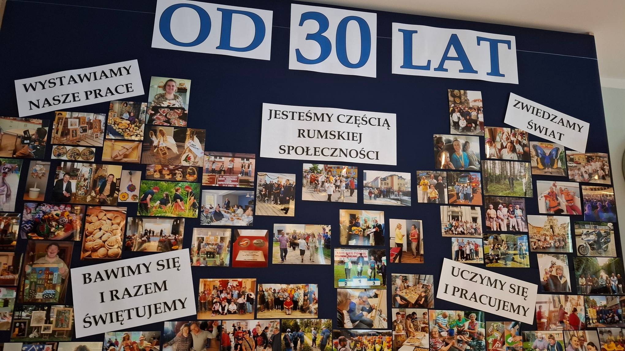 Niebieska tablica pamiątkowa z dużym napisem "OD 30 LAT" oraz licznymi fotografiami podopiecznych, podzielonymi na sekcje tematyczne ukazujące codzienne aktywności i historię placówki
