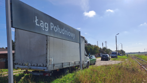 Na zdjęciu widać tablicę przystanku kolejowego Łąg Południowy, peron i tory