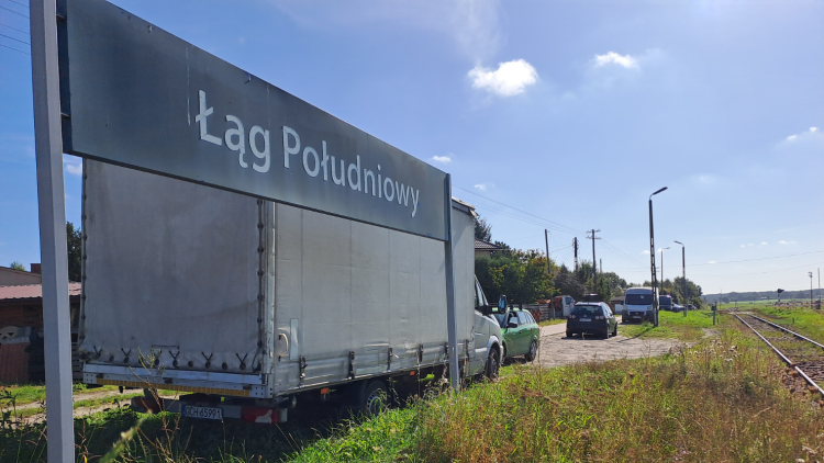 Na zdjęciu widać tablicę przystanku kolejowego Łąg Południowy, peron i tory