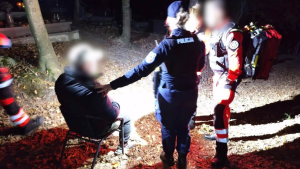 Na zdjęciu widać policjantów, ratownika medycznego i poszkodowanego na krzesełku, któremu udzielana jest pomoc
