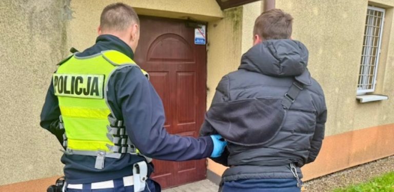 Męążczyzna w kajdankach prowadzony przez policjanta