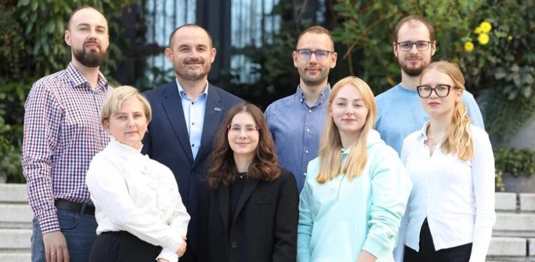 Na zdjęciu stoją w dwóch rzędach osoby zaangażowane w opracowanie nowego opakowania