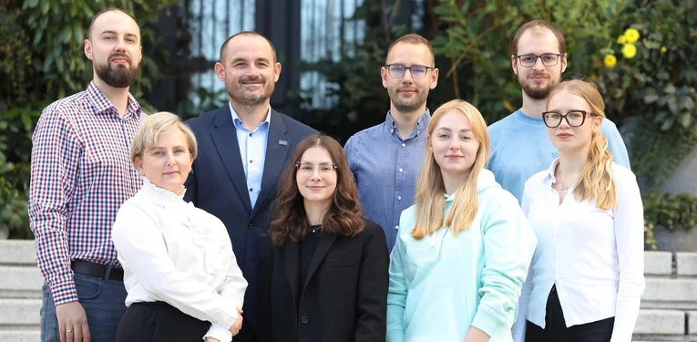 Na zdjęciu stoją w dwóch rzędach osoby zaangażowane w opracowanie nowego opakowania